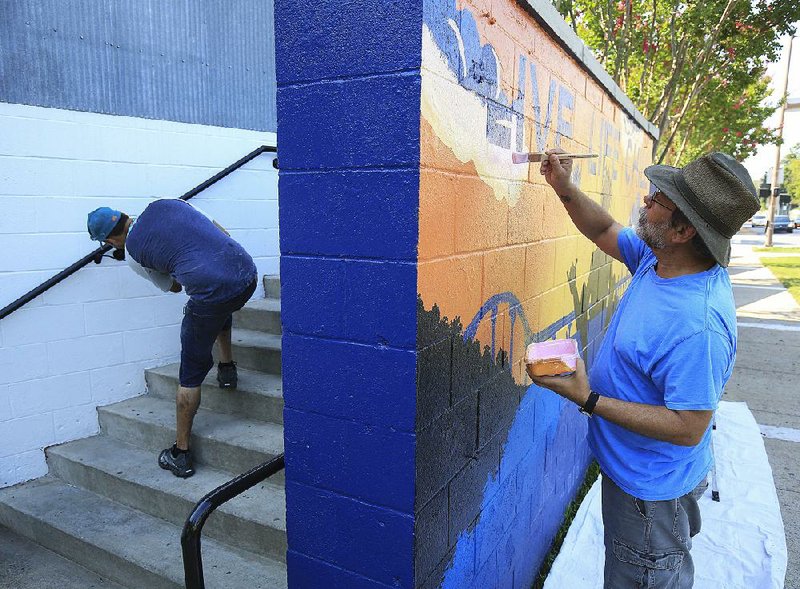 Arkansas Democrat-Gazette/STATON BREIDENTHAL --8/2/18-- Employee Andrew Midgett (left) touches up the paint Thursday on a hand rail at the new Live Life Chill restaurant in the River Market as artist Daniel Adams from McRae paints a sign for the business. 