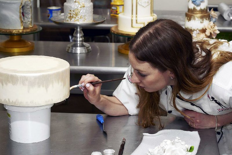 Gabriela Plump, Elaine Sciolino’s younger daughter, decorates a fake cake for her sister’s wedding day at NY Cake in New York. Elaine Sciolino found a picture-perfect, and inedible, wedding cake as a do-it-yourself bargain for her daughter’s big day, but the guests still got to eat cake — sheet cake.