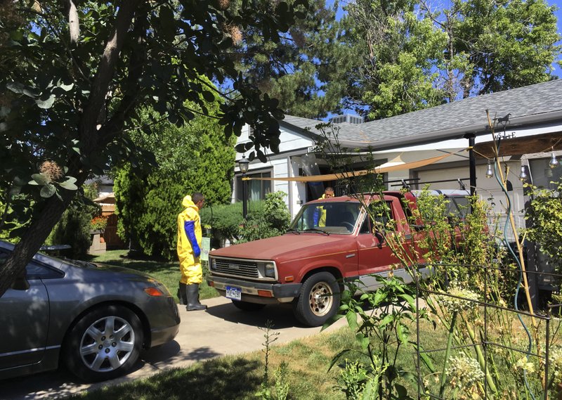 In this Tuesday, July 31, 2018 photo workers clean up a home where a homeowner shot and killed an intruder and was then killed by police responding to calls of a disturbance in Aurora, Colo. just outside Denver. Police have released few details about the shooting so far, saying they need to balance transparency with ensuring a credible investigation. (AP Photo/Colleen Slevin)