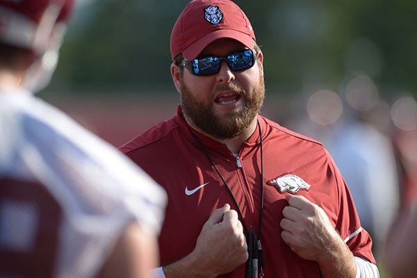 Arkansas offensive line coach Dustin Fry speaks to his players Friday, Aug. 3, 2018, during practice at the university practice field on campus in Fayetteville. 