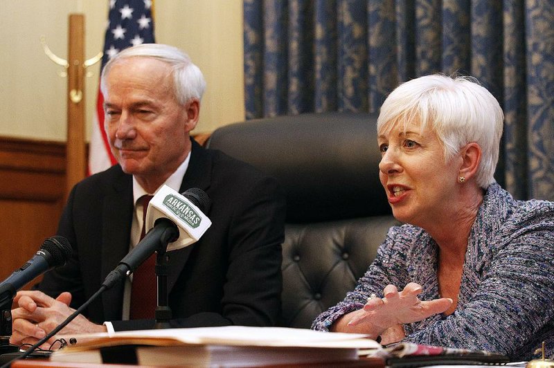 Gov. Asa Hutchinson and Human Services Department Director Cindy Gillespie discuss the state’s Medicaid program at a news conference Friday at the Capitol.