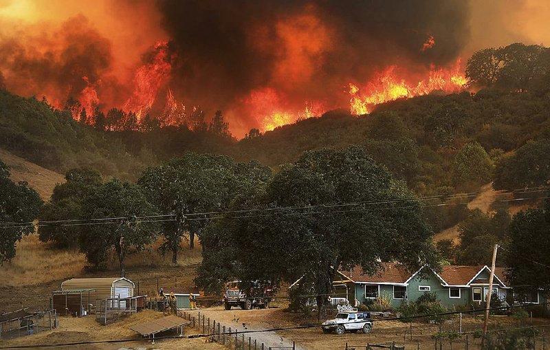 A wildfire advances down a hillside Thursday near Lakeport in Northern California. The fire contin- ues to burn, and firefighters are expecting conditions to worsen over the weekend.