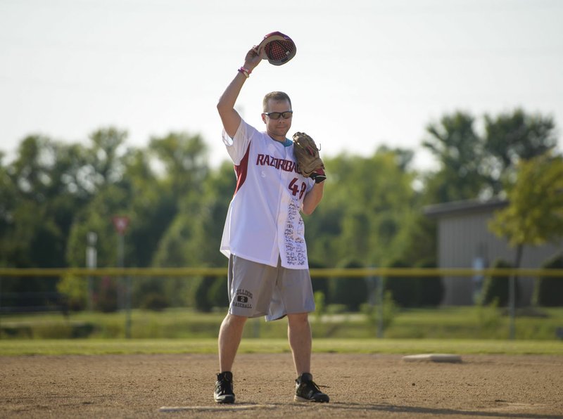 Matt Mika waves Friday at fans before throwing the rst pitch during Tyson Foods’ annual softball tournament at the Rogers Regional Sports Park in Rogers. Mika, director of government relations for Tyson, was shot twice at the GOP Congressional baseball team practice in Alexandria, Va., in June 2017.