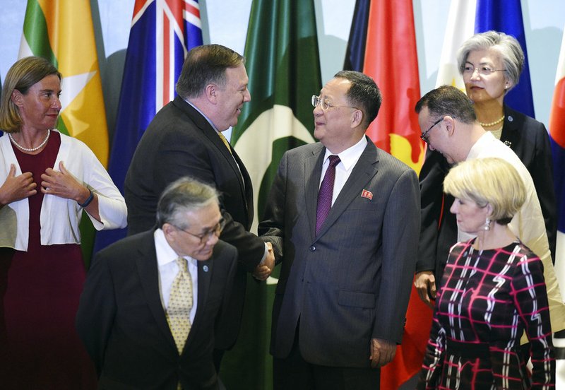 U.S. Secretary of State Mike Pompeo, center left, greets North Korea's Foreign Minister Ri Yong Ho as they prepare to pose for a group photograph with other foreign ministers at the 25th ASEAN Regional Forum Retreat in Singapore, Saturday, Aug. 4, 2018. 