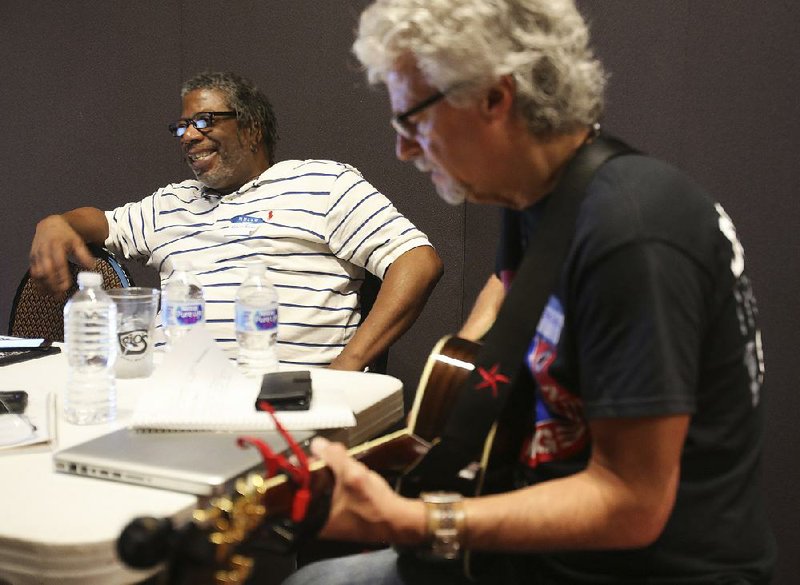 Navy veteran Edwin Brown (left) listens Saturday as Steve Dean plays the song Brown wrote during a retreat with Operation Song at the MacArthur Museum in Little Rock.