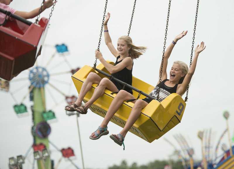 Lauren Williams and Caroline Costantini take a spin on the Whirlwind on the final day of last year's Benton County Fair in Bentonville. Benton County kicks off the county fair season on Aug. 7.