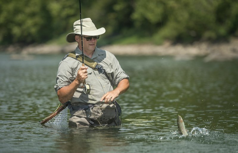 In this file photo Greg Darling of Carbondale, Ill., brings in a rainbow trout Friday while fishing in the White River below Beaver Dam.