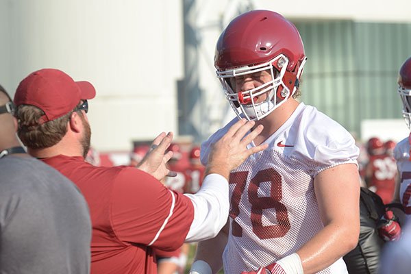 Arkansas offensive lineman Dalton Wagner (78) speaks with position coach Dustin Fry as he participates in a drill Friday, Aug. 3, 2018, during practice at the university practice field on campus in Fayetteville.