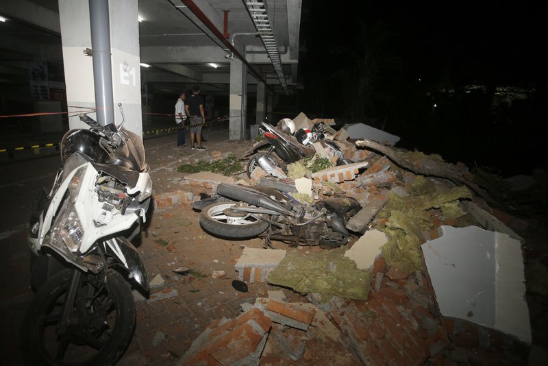 Debris on top of a motorcycles after an earthquake in Bali, Indonesia, Sunday, Aug. 5, 2018. A strong earthquake struck the Indonesian tourist island of Lombok on Sunday, killing at least three people and shaking neighboring Bali, one week after another quake on Lombok killed more than a dozen. (AP Photo/Firdia Lisnawati)