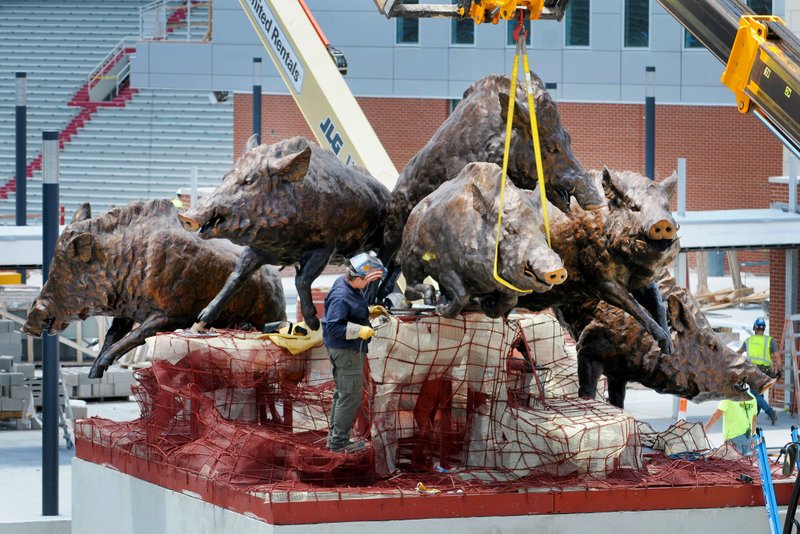 NWA Democrat-Gazette/DAVID GOTTSCHALK Work continues Monday on the Wild Band of Razorbacks sculpture on the northeast corner of the University of Arkansas' Reynolds Razorback Stadium in Fayetteville. The bronze sculpture consists of six razorbacks and honors the university's 1964 national championship football team. The sculpture will be about 20 feet tall and 30 feet wide with bronze razorbacks six feet tall and 12 to 14 feet long.