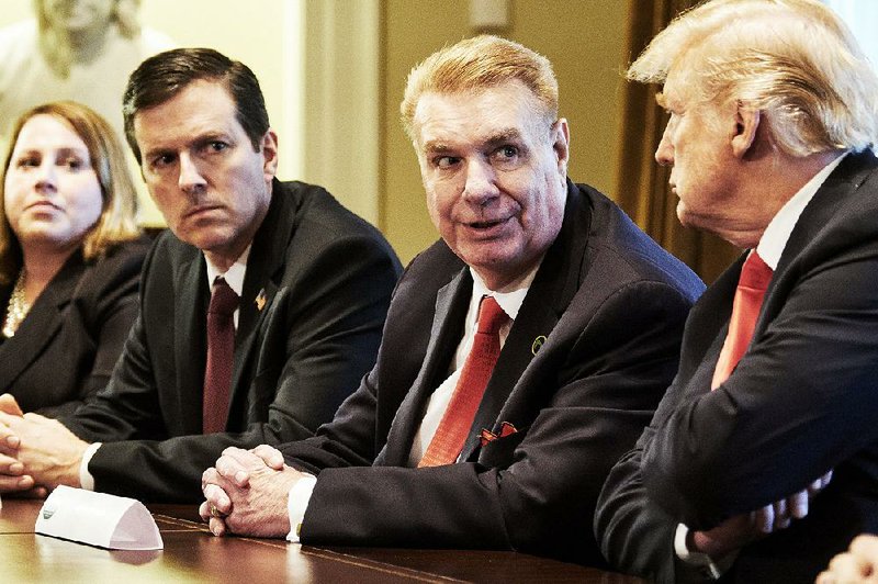 John Ferriola (middle), president and CEO of Nucor Corp., talks with President Donald Trump during a meeting in the White House in March.