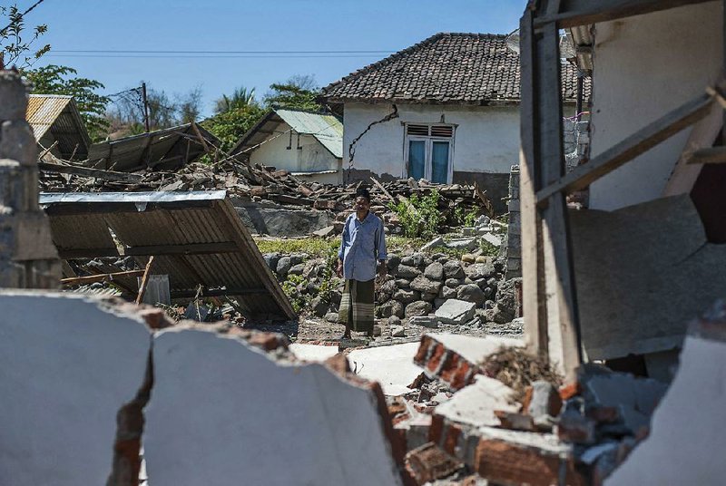 A man walks through a village destroyed by a strong earthquake in Kayangan, Lombok Island, Indonesia, on Monday.