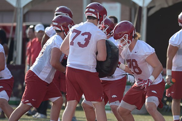 Arkansas offensive linemen Dalton Wagner (78) and Noah Gatlin (73) participate in a drill Friday, Aug. 3, 2018, during practice at the university practice field on campus in Fayetteville.