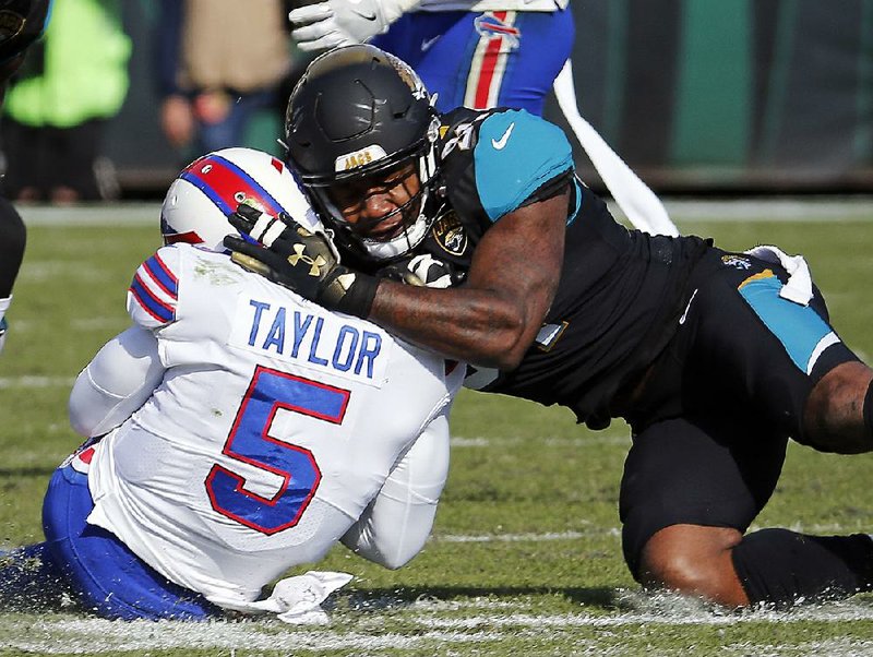 Jacksonville Jaguars defensive end Yannick Ngakoue (right) drew a penalty for helmet-to-helmet contact on Buffalo Bills quarterback Tyrod Taylor in a wild-card playoff game Jan. 7. The NFL’s new helmet contact rules are generating plenty of grumbling among players around the league. 