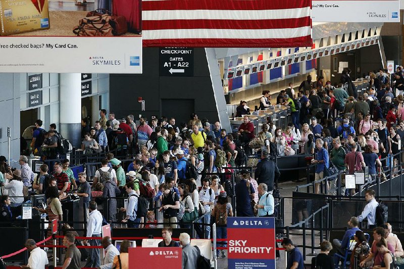 Passengers wait to pass through security earlier this year at Logan International Airport in Boston. Consumer advocates see good and bad things in two bills being considered by Congress that will affect travelers.  