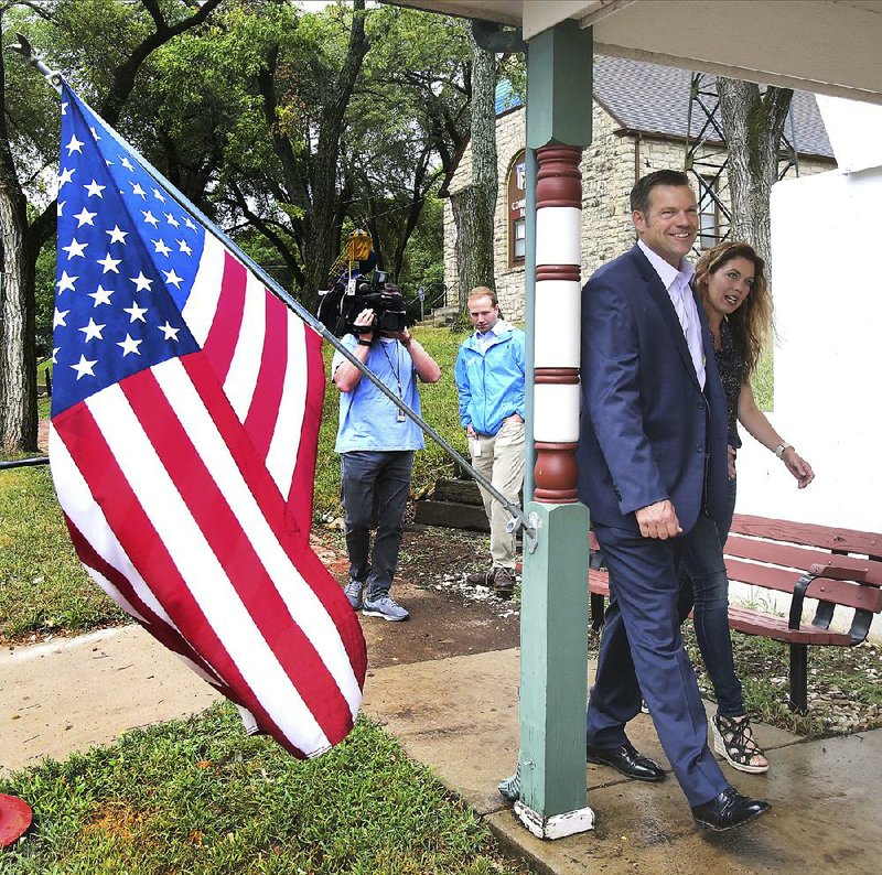 Kansas Secretary of State Kris Kobach, seeking the Republican nomination for governor, arrives to vote Tuesday in Lecompton with his wife, Heather. 