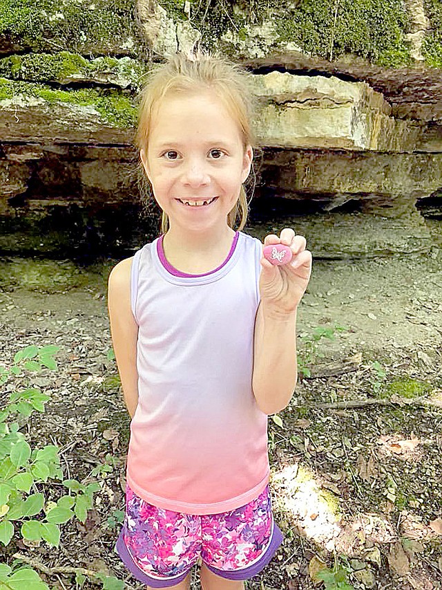 Photo submitted Josie Edwards poses with a Bella Vista Rock for a photo that was later posted on Facebook. She and her family also paint and hide rocks as part of the game that has been going on for two years.