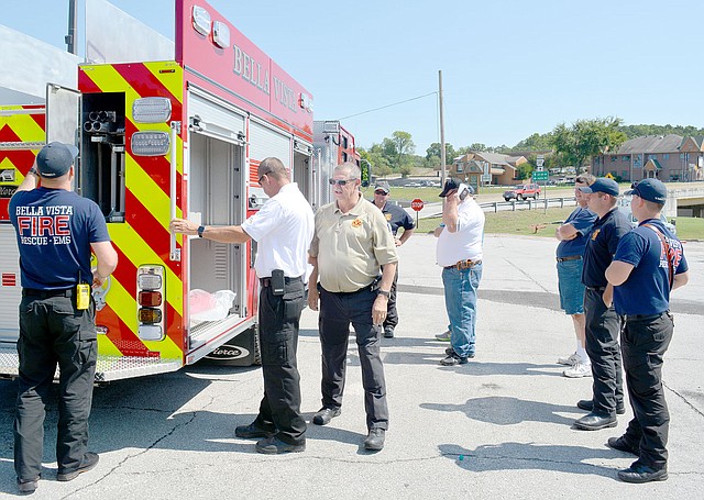 Keith Bryant/The Weekly Vista Bella Vista firefighters take a look at the storage compartments on Bella Vista's new pump truck.