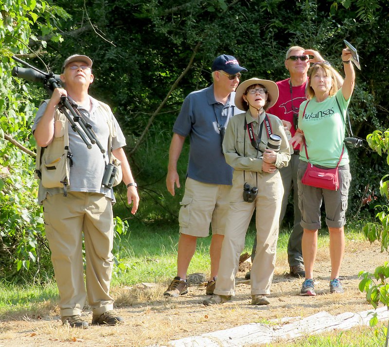 Westside Eagle Observer/Randy Moll Joe Neal (left) and other members of the Northwest Arkansas Audubon Society stop along the Eagle Watch Nature Trail on Saturday (Aug. 4, 2018) to view a bird. The group of local bird watchers and photographers was there on a field trip Saturday morning.
