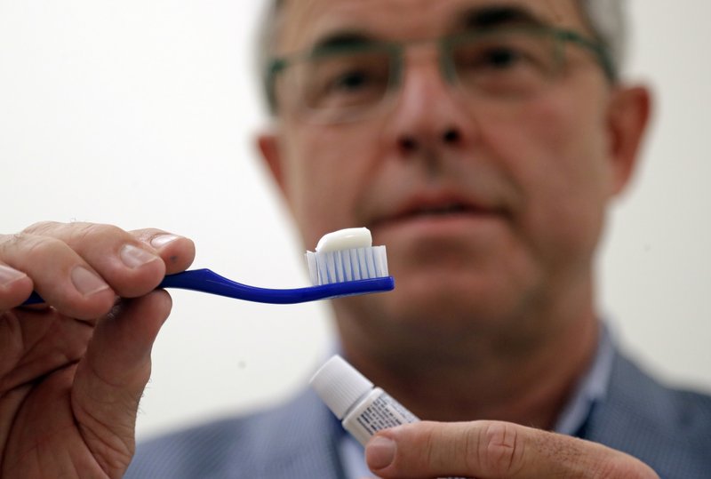 The Associated Press TOOTHBRUSHING: In this photo taken Friday Philippe Hujoel, a dentist and University of Washington professor, holds a toothbrush and toothpaste as he poses for a photo in an office at the school in Seattle. Dental health experts worry that more people are using toothpaste that skips the most important ingredient - the fluoride - and leaves them at a greater risk of cavities.