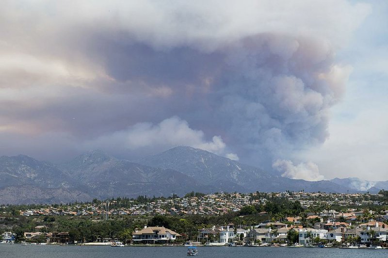 Smoke rises Wednesday from a wildfire in the mountains near Mission Viejo, Calif. The blaze consumed mostly unoccupied land, but fire crews feared that it could threaten foothill communities. 