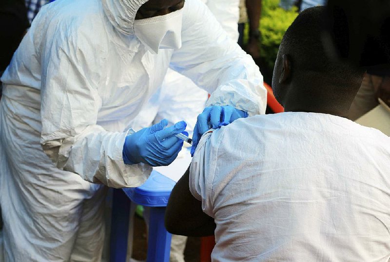A health care worker from the World Health Organization gives a front-line aid worker an Ebola vaccination Wednesday in Mangina, Democratic Republic of Congo.  
