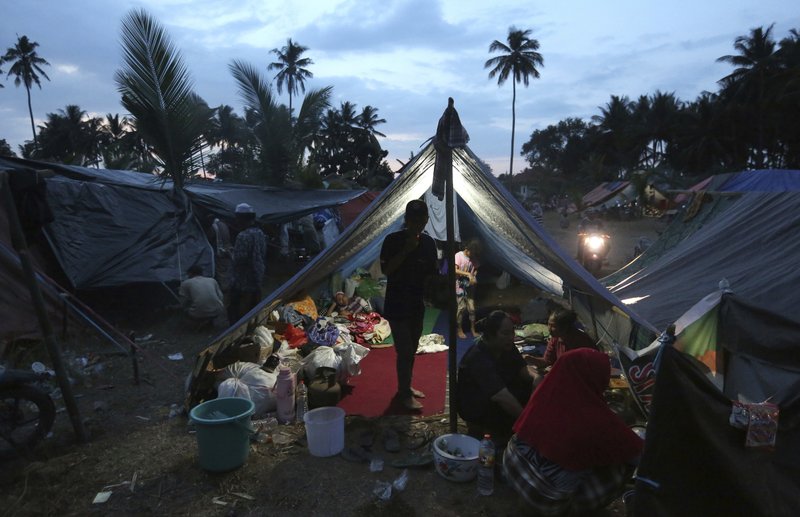Villagers gather at a temporary shelter after fleeing their damaged village affected by Sunday's earthquake in North Lombok, Indonesia, Wednesday, Aug. 8, 2018. Aid has begun reaching isolated areas of the Indonesian island struggling after an earthquake killed over 100 people as rescuers intensify efforts to find those buried in the rubble. (AP Photo/Tatan Syuflana)