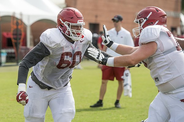 Brian Wallace (left) and Silas Robinson, Arkansas offensive linemen, participate in a drill Wednesday, Aug. 8, 2018, at the Arkansas practice field in Fayetteville.