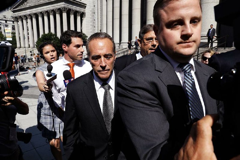 Rep. Chris Collins, R-N.Y., (center) exits federal court Wednesday in New York after he and his son were indicted on charges of insider trading. 