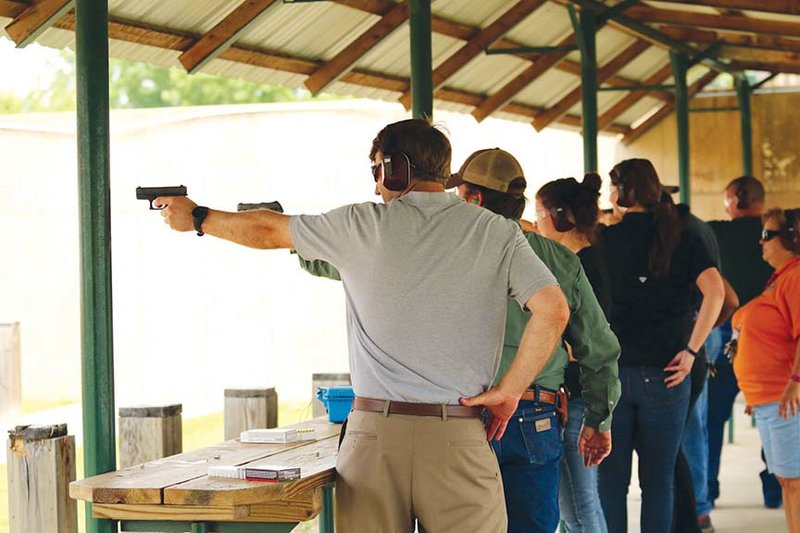 Visitors take aim with handguns under the watchful guidance of Arkansas Game and Fish Commission personnel at the Dr. James E. Moore Jr. Firing Range near Mayflower.
