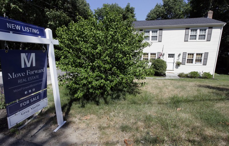 In this July 9, 2018, photo a for sale sign stands outside a pre-existing home in Walpole, Mass. (AP Photo/Steven Senne)