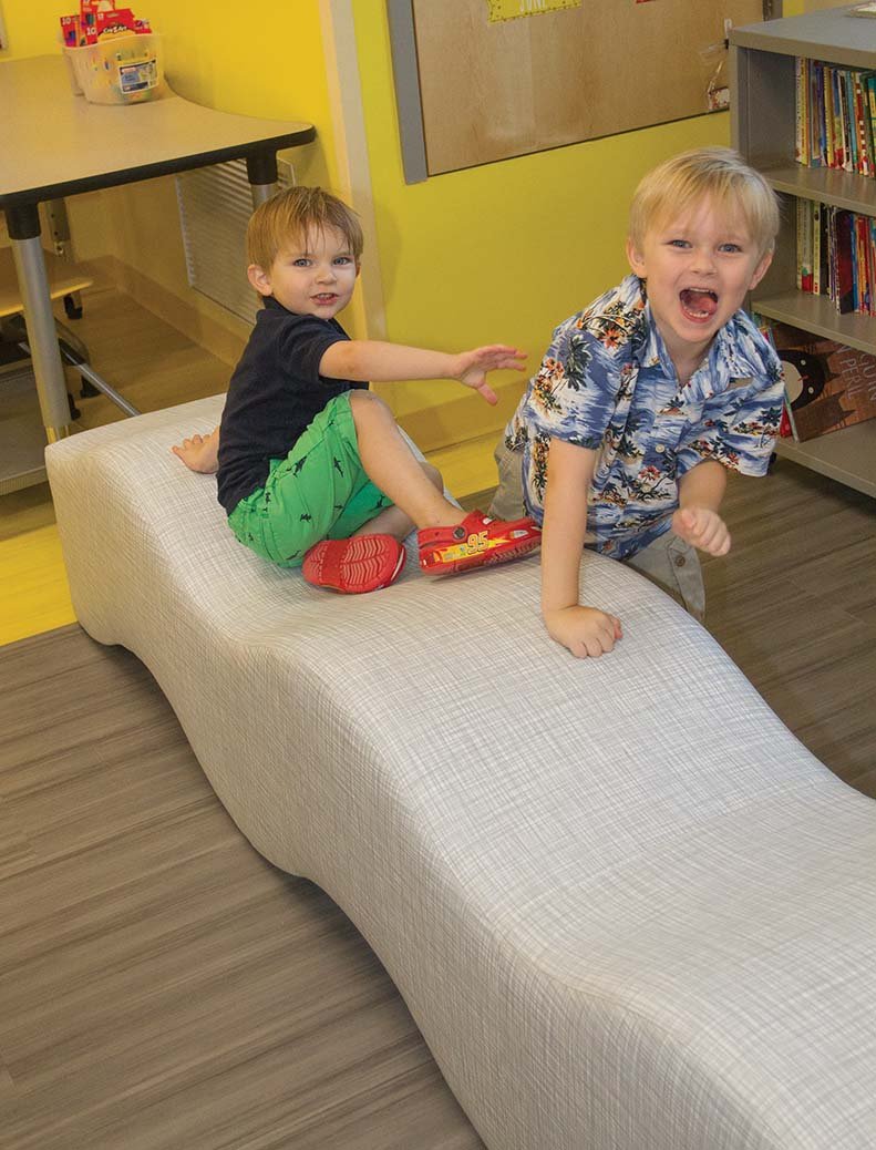 Brothers Owen, left, and Thor Millard crawl on a new couch in the classroom of fourth-grade math teacher Jennifer Simpson during an open house for the new Bobby G. Lester Elementary School in Jacksonville on Wednesday.