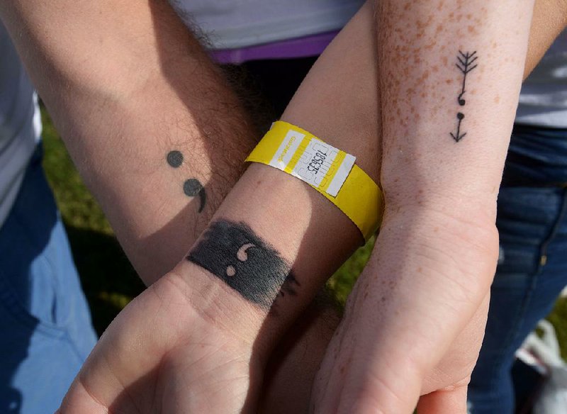 Youths with tattoos calling attention to those suffering from depression and thoughts of suicide take part in an American Foundation for Suicide Prevention event in Bentonville in September 2016. 