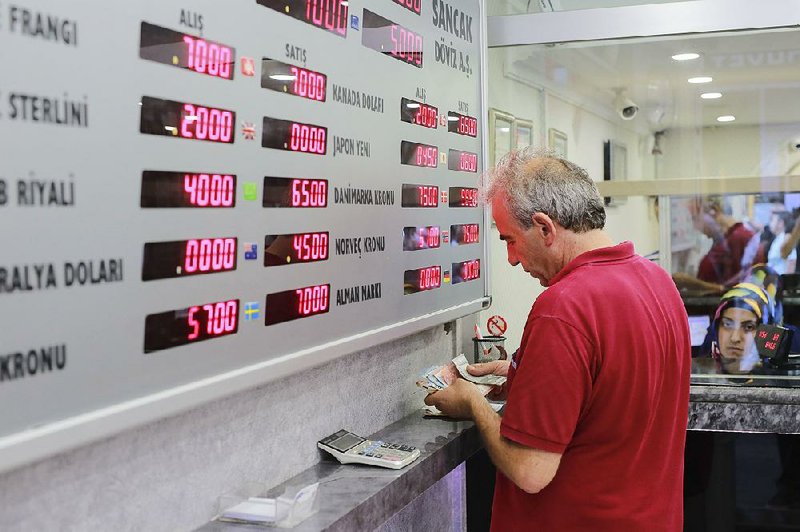 A man counts his Turkish liras Friday at a currency exchange in Istanbul. Turkish President Recep Tayyip Erdogan advised Turks to sell their dollars as the lira slides.  