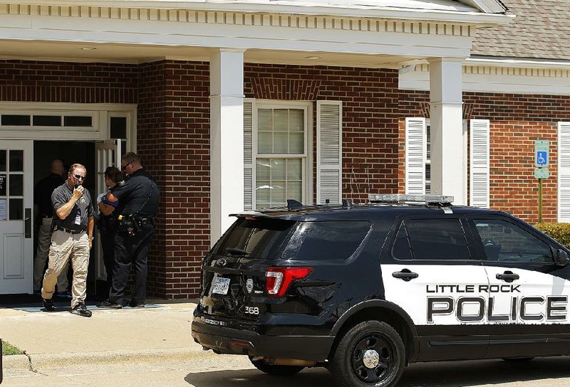 Little Rock police officers investigate a robbery Friday at the U.S. Bank at Geyer Springs and Baseline roads. A suspect was arrested.