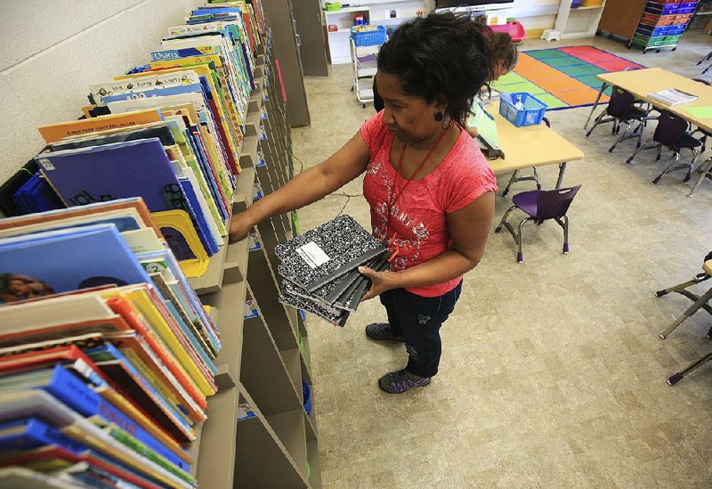 Arkansas Democrat-Gazette/STATON BREIDENTHAL --8/10/18--  Kindergarten teacher Angela Sewell distributes notebooks for students Friday as she prepares for the beginning of the school year at Seventh Street Elementary School in North Little Rock. Classes in the Little Rock, North Little Rock and Pulaski County Special school districts begin Monday. 