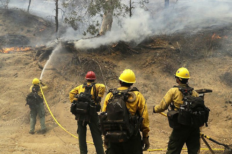 Firefighters make a stand in front of an advancing wildfire Friday in Lake Elsinore, Calif., as they work to protect foothill neighborhoods.  