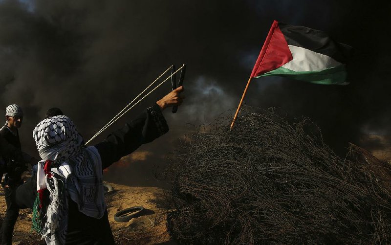 Palestinian protesters hurl stones and burn tires along the Gaza Strip’s border with Israel as violence flared Friday despite a cease-fire between Hamas and Israel.  