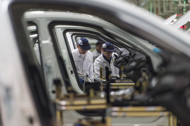 In this Feb. 6, 2017, photo, workers assemble cars at the Dongfeng Honda automotive plant in Wuhan in central China's Hubei province. China's auto sales shrank by 5.3 percent in July 2018 from a year earlier as SUV demand sagged, adding to signs of economic malaise amid a tariff battle with Washington. (Chinatopix via AP)