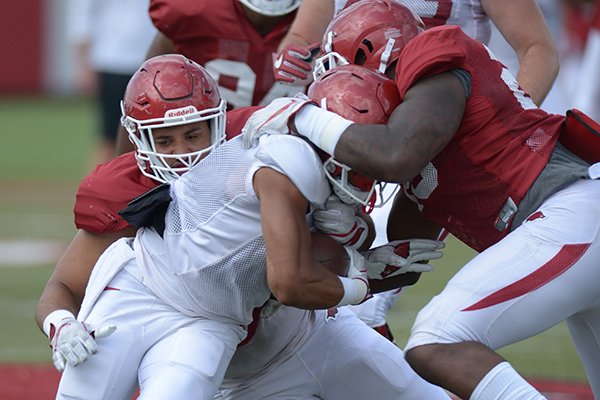 Arkansas running back Rakeem Boyd (left) is hit by linebacker Giovanni LaFrance (20) Thursday, Aug. 9, 2018, during practice at the university's practice facility in Fayetteville. 