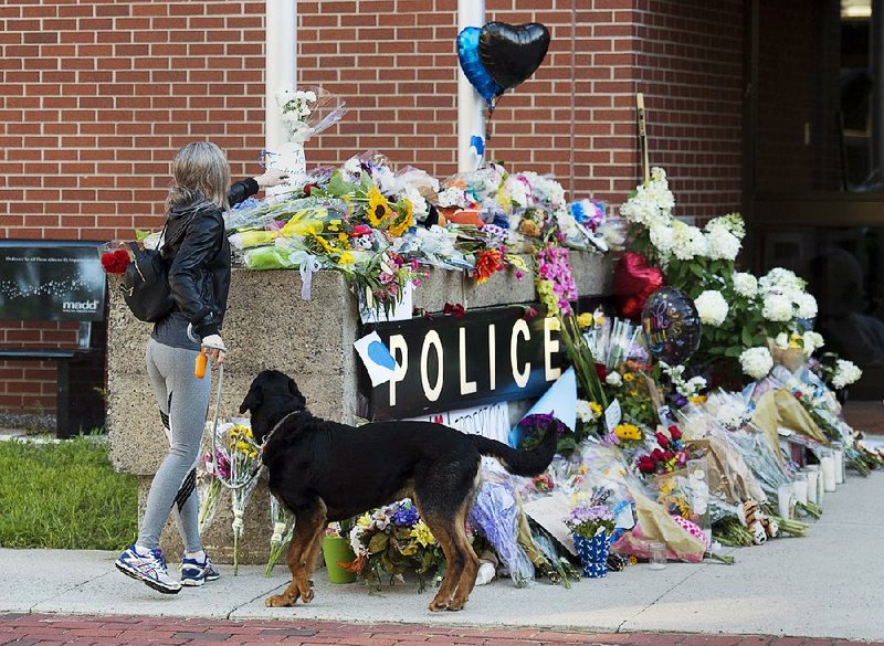 Flowers form a makeshift memorial Saturday outside the police station in Fredericton, New Brunswick.