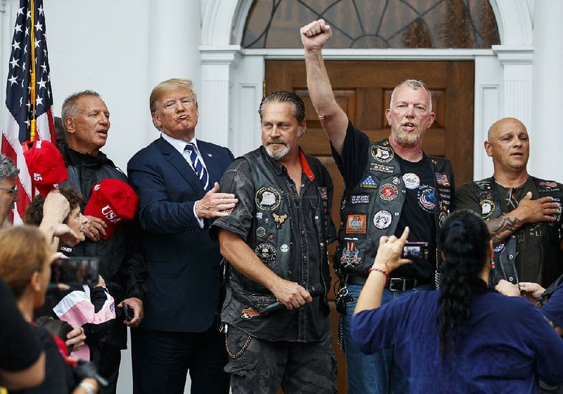 President Donald Trump joins motorcyclists to recite the Pledge of Allegiance in the rain at a “Bikers for Trump” event Saturday at his golf resort in Bedminster, N.J.