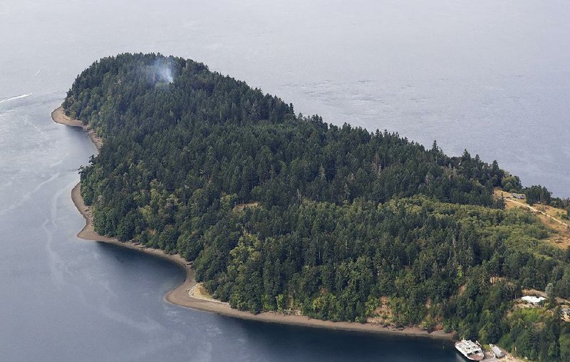 Smoke rises Saturday near the tip of Ketron Island in the Puget Sound southwest of Seattle, where a Horizon Air employee crashed a stolen plane Friday evening.