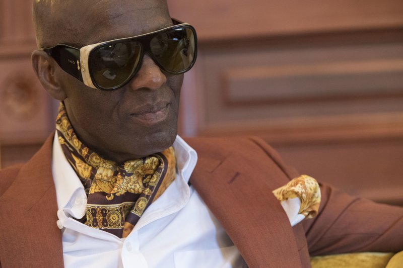 In this Thursday, July 19, 2018 photo, designer Dapper Dan is seen during an interview at his atelier in the Harlem neighborhood of New York. Harlem designer Dapper Dan spent years in the 1980s with a client list that included the who's who of hip-hop before legal issues over the clothes he was making got in the way. Now the fashion groundbreaker is back after more than two decades out of the public eye. He's got a partnership with Gucci and the likes of superstar entertainer Beyonce among those wearing his designs. (AP Photo/Mary Altaffer)