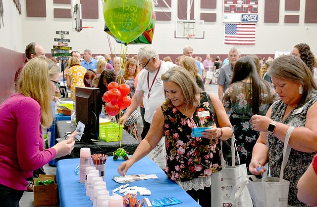 Janelle Jessen/Siloam Sunday Teachers and school employees visited the booths of local businesses during the annual Chamber of Commerce Back to School Breakfast on Wednesday morning.