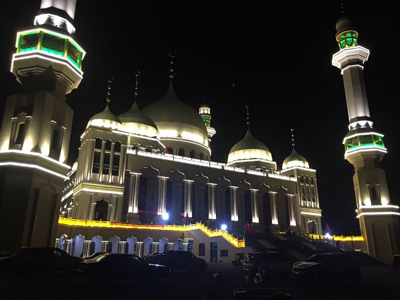 Vehicles are parked outside the Grand Mosque in Weizhou in northwestern China's Ningxia Hui Autonomous Region, early Saturday, Aug. 11, 2018. Thousands of Muslims gathered at a mosque in northwestern China on Friday to protest its planned demolition in a rare, public pushback to the government's efforts to rewrite how religions are practiced in the country. (AP Photo/Sam McNeil)