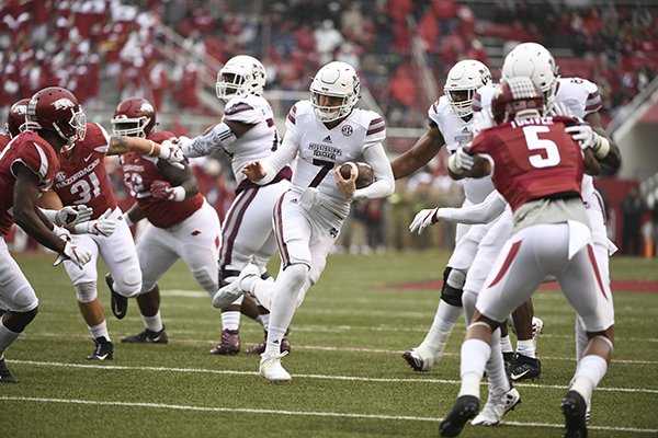Mississippi State quarterback Nick Fitzgerald slips past the Arkansas defense to score a touchdown during the first half of an NCAA college football game Saturday, Nov. 18, 2017 in Fayetteville, Ark. (AP Photo/Michael Woods)