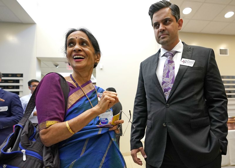 In this Sunday, July 29, 2018, photo, Thara Narasimhan, left, talks with Democrat for Congress candidate Sri Kulkarni during a fundraiser in Houston. Narasimhan, who hosts an Hindu radio program in Houston, has already given $1,200 to the Democrat running against Republican U.S. Rep. Pete Olson. (AP Photo/David J. Phillip)