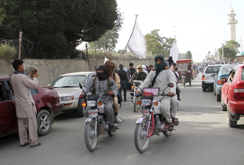 FILE - In this June 16, 2018 file photo, Taliban fighters ride their motorbikes inside Ghazni city, capital of Ghazni province, west of Kabul, Afghanistan. An Afghan official said Sunday, Aug. 12, 2018, that security forces are battling the Taliban for the third straight day following a massive insurgent attack into the key city of Ghazni. The Taliban pushed into Ghazni from different directions on Friday and destroyed a telecommunication tower, cutting off landline and cell phone communications. (AP Photo, File)