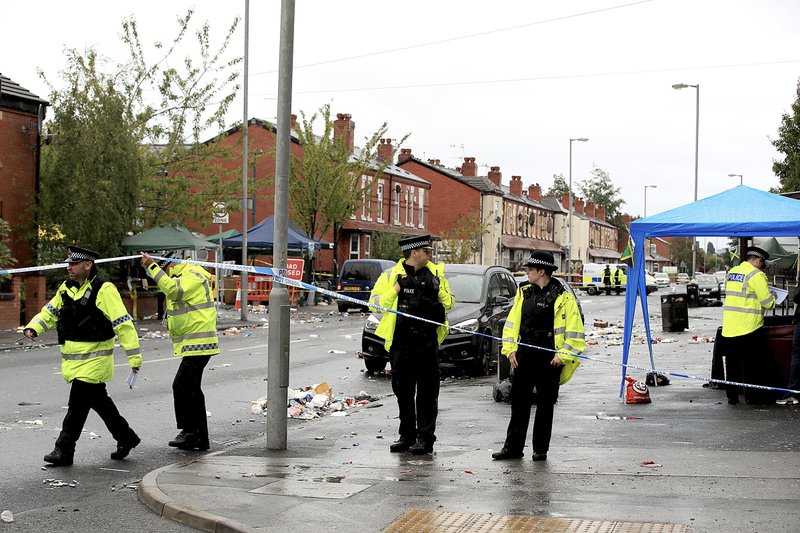 Police officers stand at the scene on Claremont Road in Manchester after a shooting Sunday.